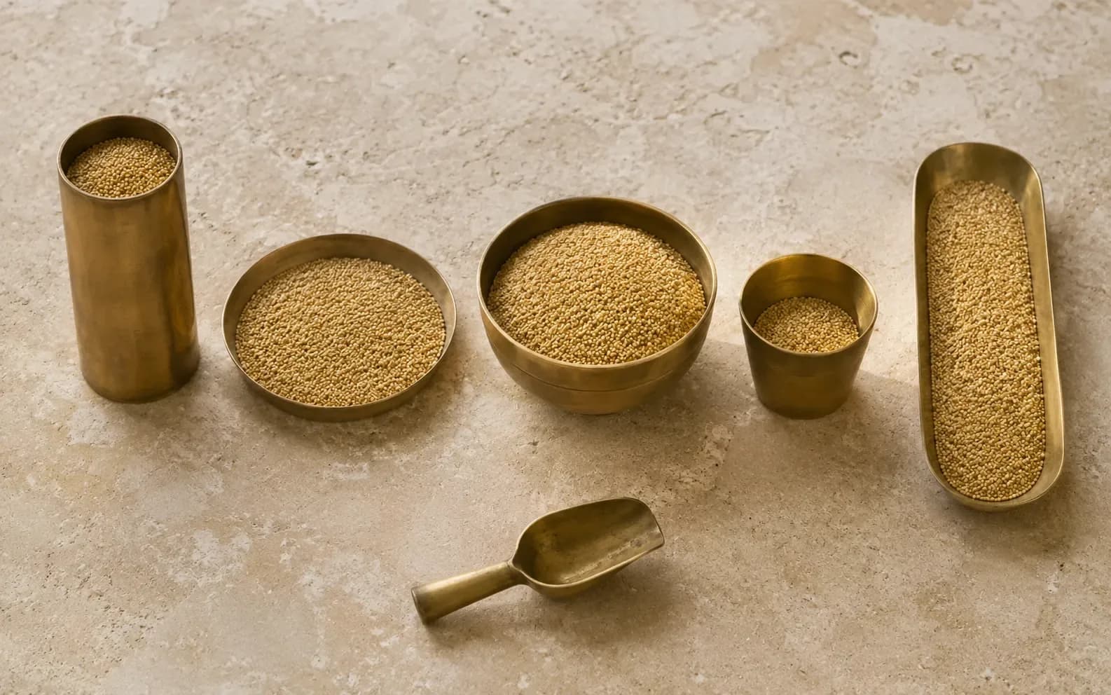 Five measuring vessels of completely different shapes standing in a row, each holding the same grain at a level that makes the amount look different.