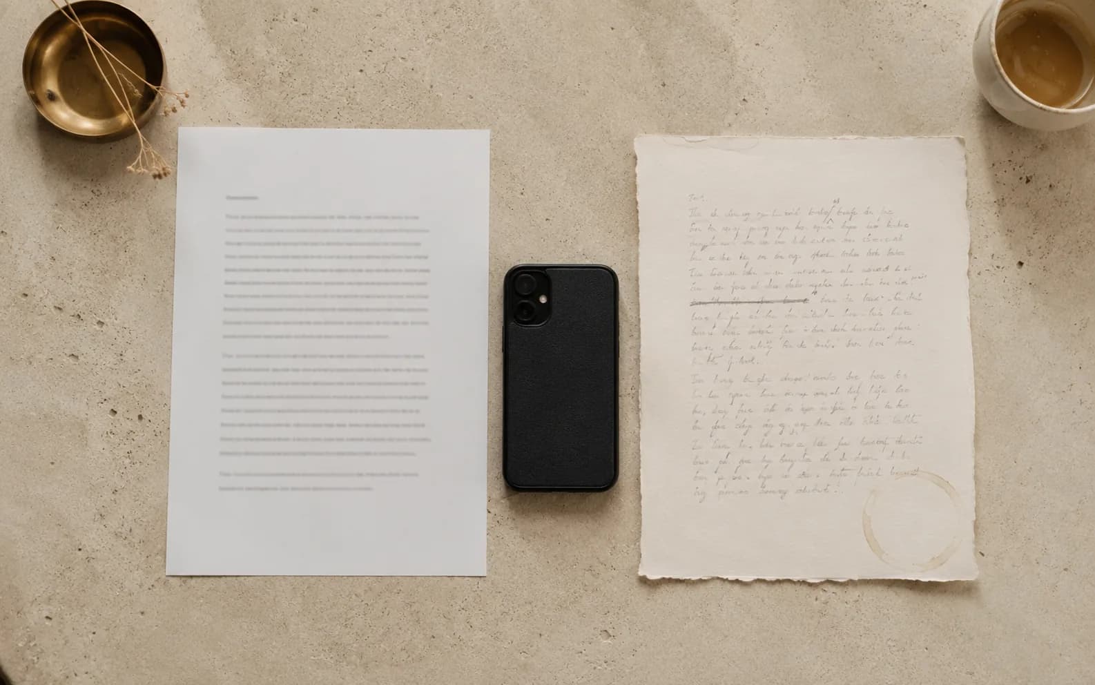 The same short piece of writing twice: typed on a crisp even sheet on one side, handwritten on a torn edged sheet with a coffee ring and a struck through line on the other.